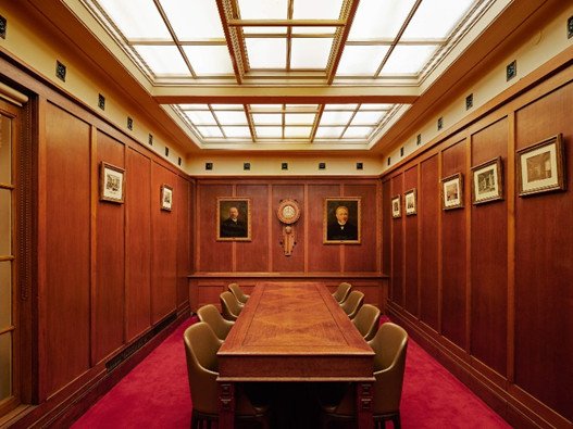 De Heerenkamer — mahonie, kroonluchter, rood tapijt